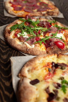 A lot of italian pizza on wooden table