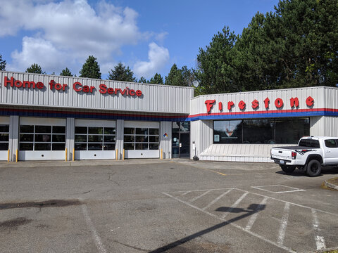 Woodinville, WA / USA - circa April 2020: Street view of a Firestone Complete Auto Care Center on a sunny day.