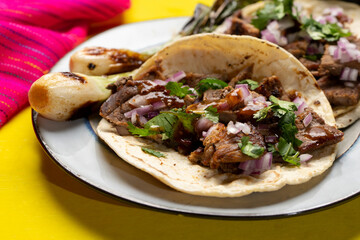 Grilled beef steak tacos on yellow background. Mexican food