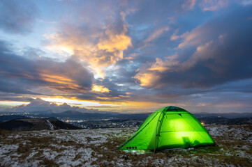 Tent on top of a mountain against the backdrop of a sunset in the Carpathians