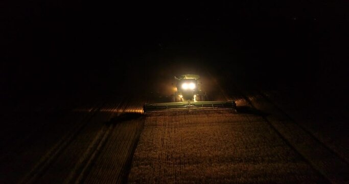 Tractor harvesters working at night countryside corn fields drone aerial view 4K 