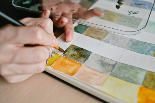 Girl artist paints a watercolor color charts