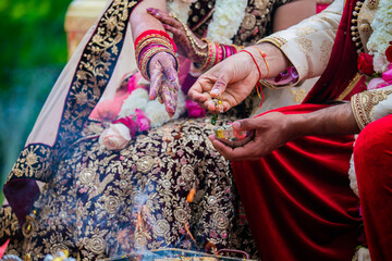 Indian Hindu couple's hands close up, wedding ceremony, religious items and rituals, pooja