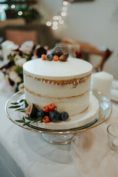Simple vanilla naked cake with figs, raspberries and olive branch leaves