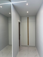 corridor with mirror and white wardrobe