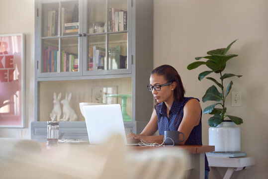 young woman thinking while working on laptop computer in her cos