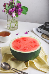 Halved Ripe Watermelon on Concrete Surface with Cup of Tea