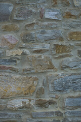 Stone wall of natural stones in different sizes; Rustic stone veneer in shades of brown and beige