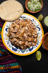 Confit pork called carnitas on dark background. Mexican food