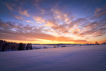 Scenic View Of Snow Covered Field Against Sky At Sunset