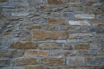 Stone wall of natural stones in different sizes; Rustic stone veneer in shades of brown and beige, in Spain