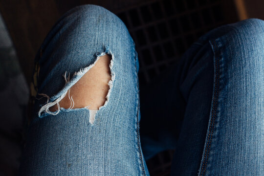 Close up of woman's legs wearing ripped jeans