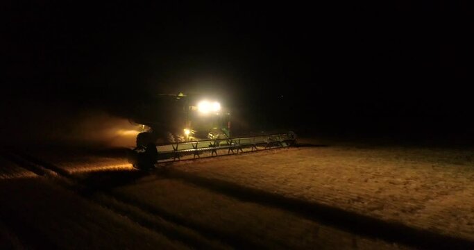 Tractor harvesters working at night countryside corn fields drone aerial view 4K 
