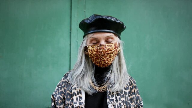 Senior woman with face mask standing outdoors, coronavirus concept.