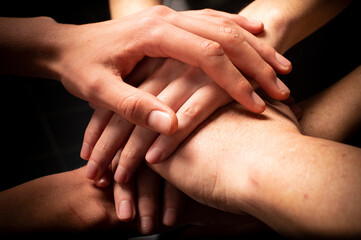 Friends with stack of hands showing unity and teamwork