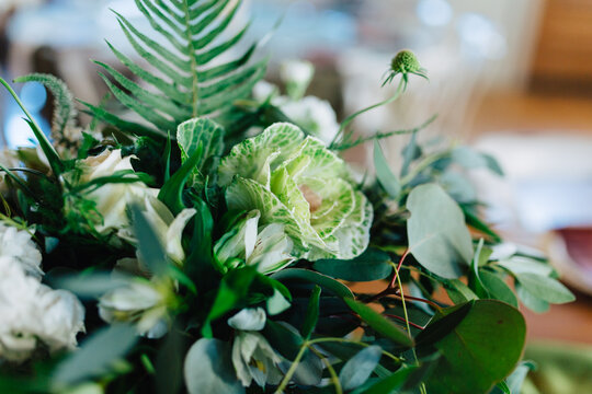 A venue set up for a wedding reception with copper and green colored decor.