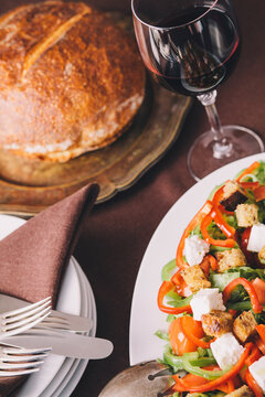 Healthy salad with croutons, glass of red wine and bread