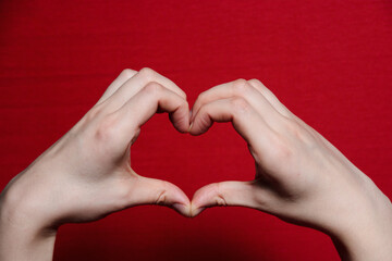 Obraz premium hands with heart on a red background