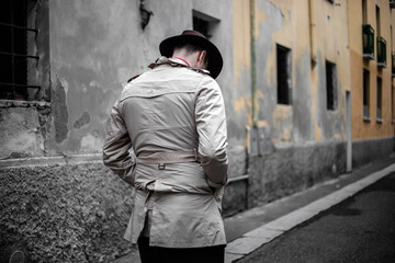 Detective walking in the city slums, view from the back