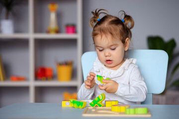 little happy toddler girl playing at the table