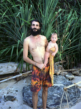 A young father with his son in a tropical environment