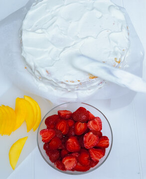 Preparing strawberry cream cake with mango