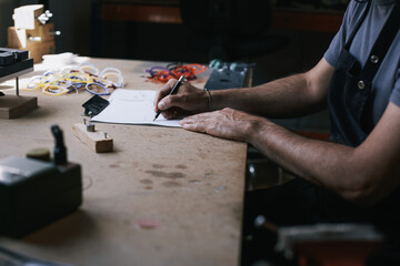 Artisan glasses designer creating and drawing in his atelier
