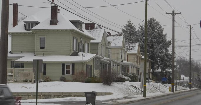 A long shot view of typical homes in a Pennsylvania small town as traffic passes out front. Winter, Pittsburgh suburbs.  	