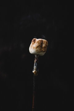 Roasted marshmallow smoking on a fire stick