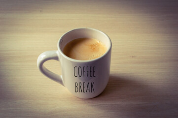A mug full of coffee with the written text 'Coffee break'