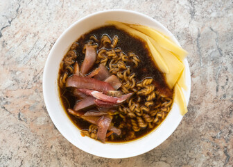 Egg noodles in a white plate and meat. Poor country cheap food