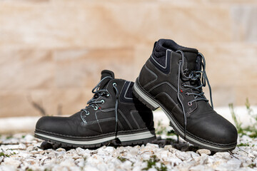 Selective focus of some gray boots for walking in the city on some white garden stones