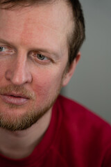 a portrait of a man looking to the left and wearing red sweaters