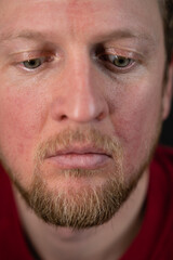 Obraz premium a close up portrait of a man in a red sweater and a disturbed facial expression and a desperate look