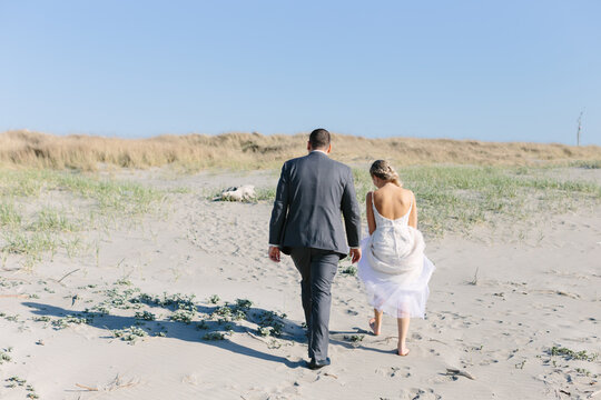 Bride and Groom Walking on Sand