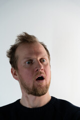 Obraz premium Portrait of a man with frizzy hair looking straight and smiling crazy when he looks like he screaming