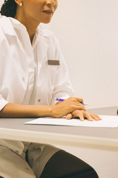 Closeup of Female Doctor Listening to Patient and Taking Notes