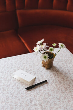 Card next to flowers on a table