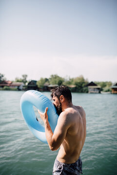 A Man Inflating A Swim Ring