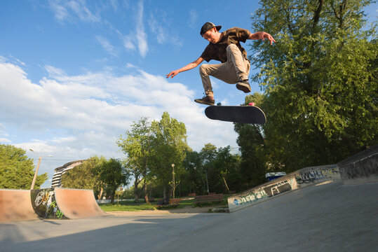 Teenagaer performing midair tricks with skateboard outdoor