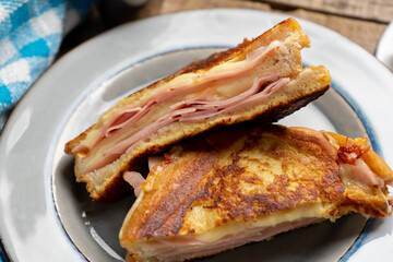 Ham and melted cheese sandwich called Monte Cristo on wooden background