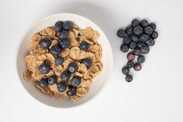 white cup with blueberries and cereals

