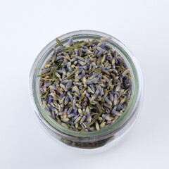 Dried lavender flowers herbs in a jar on white background