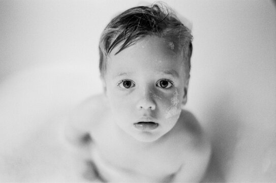 Cute young boy sitting in the bathtub