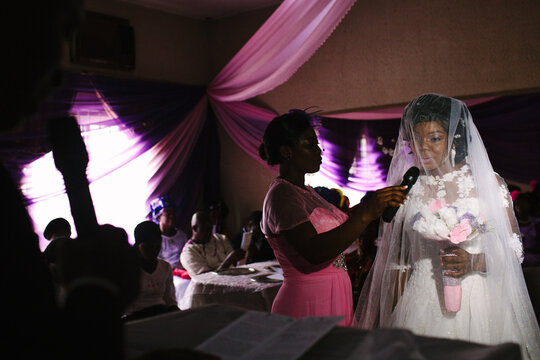 Nigerian bride speaking into a microphone during her wedding ceremony.