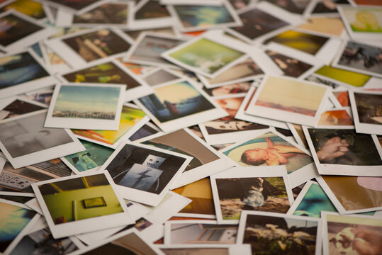 Table covered in polaroid photos.