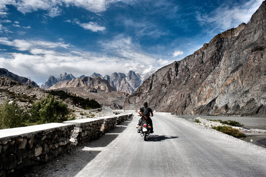 Motorcyclist rides his motorcycle on a mountain road towards the Karakorum highway