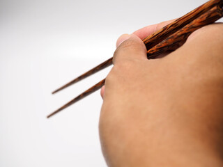 Man holding a pair of wooden chopsticks, shoot on ad white isolated background