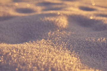 The texture of the snow on a frosty evening at sunset as a background.