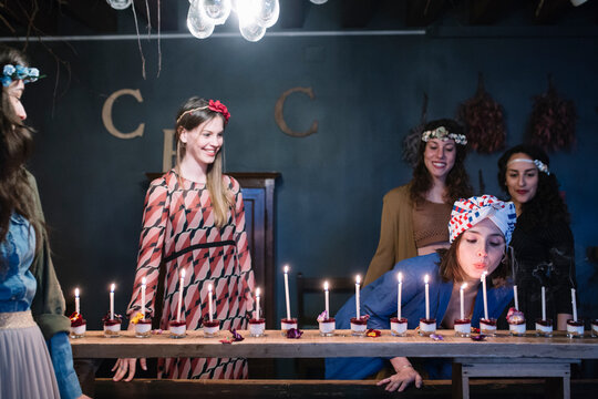 Woman blowing candles on cheesecakes